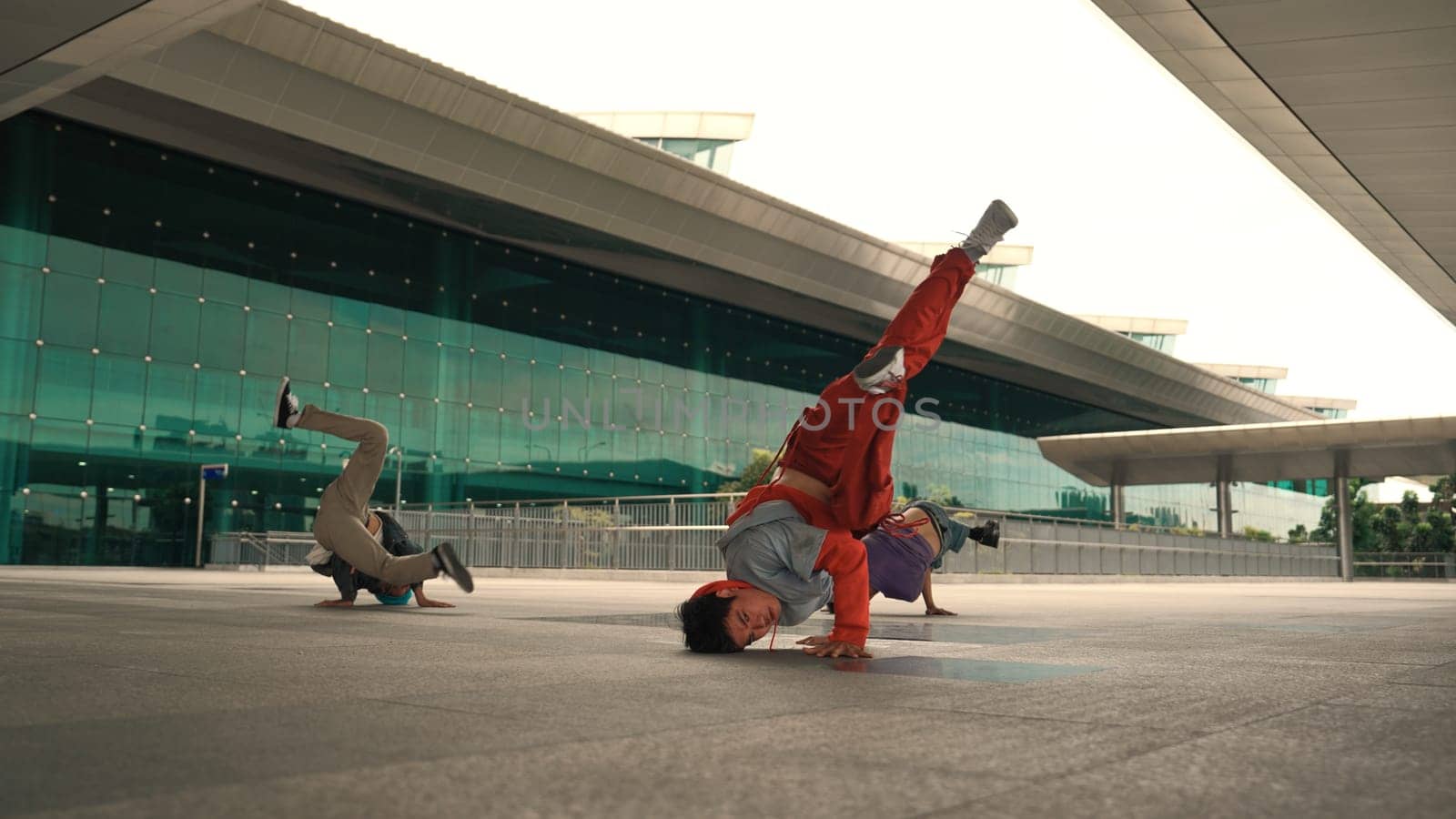 Group of happy hipster or street dancer doing freeze pose in front of mall. Funny energetic break dancer practice b-boy step dancing with friends. Outdoor sport 2024. Street dancer concept. Sprightly.