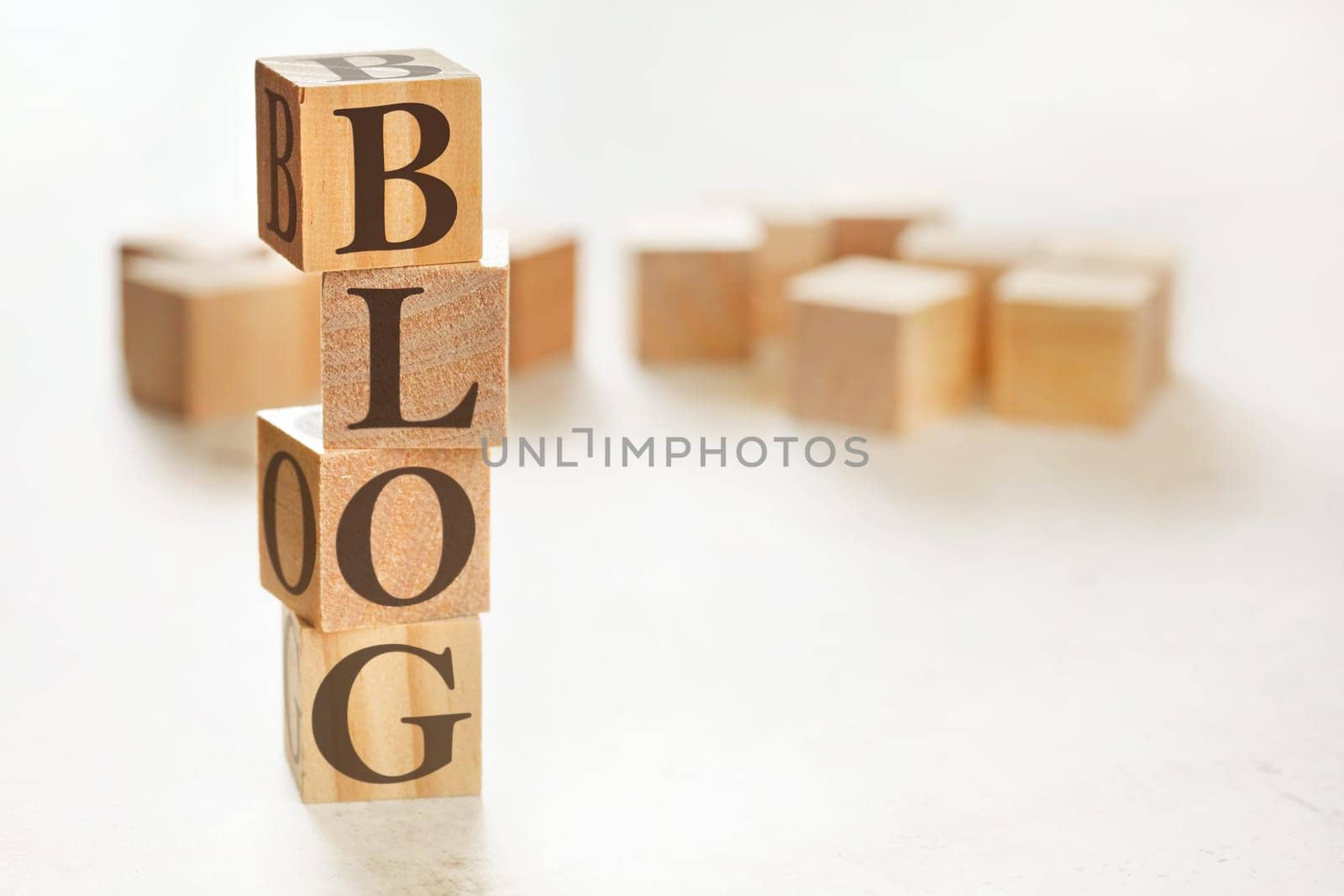 Four wooden cubes arranged in stack with word BLOG on them, space for text / image at down right corner