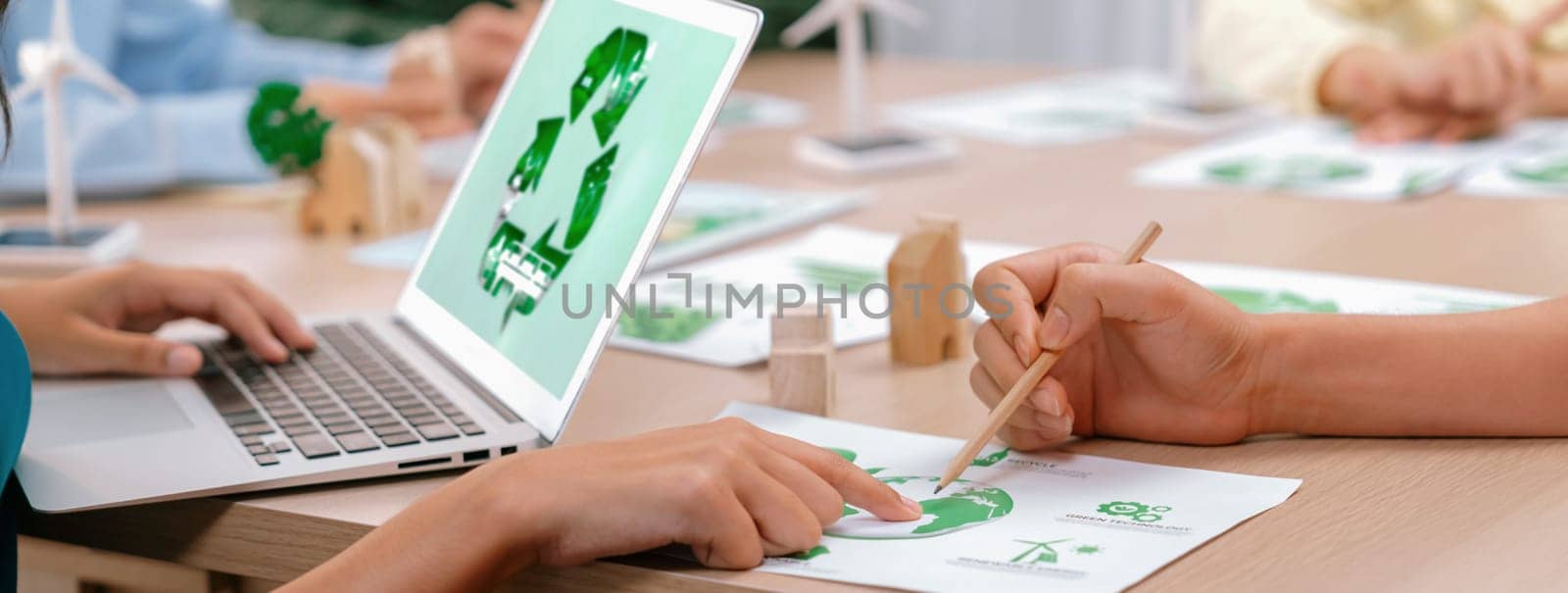 Renewable energy logo displayed on green business laptop while business team represented green design to customer. ESG environment social governance and Eco conservative concept. Closeup. Delineation.