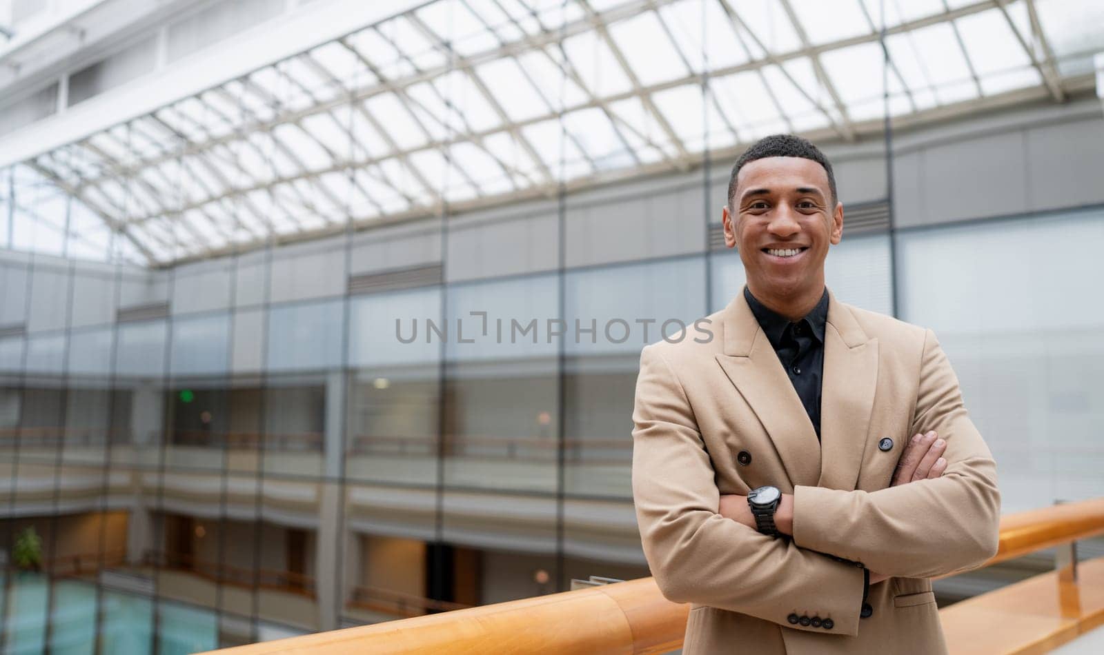 Businessman looking at the camera while standing alone in a modern workplace. High quality photo