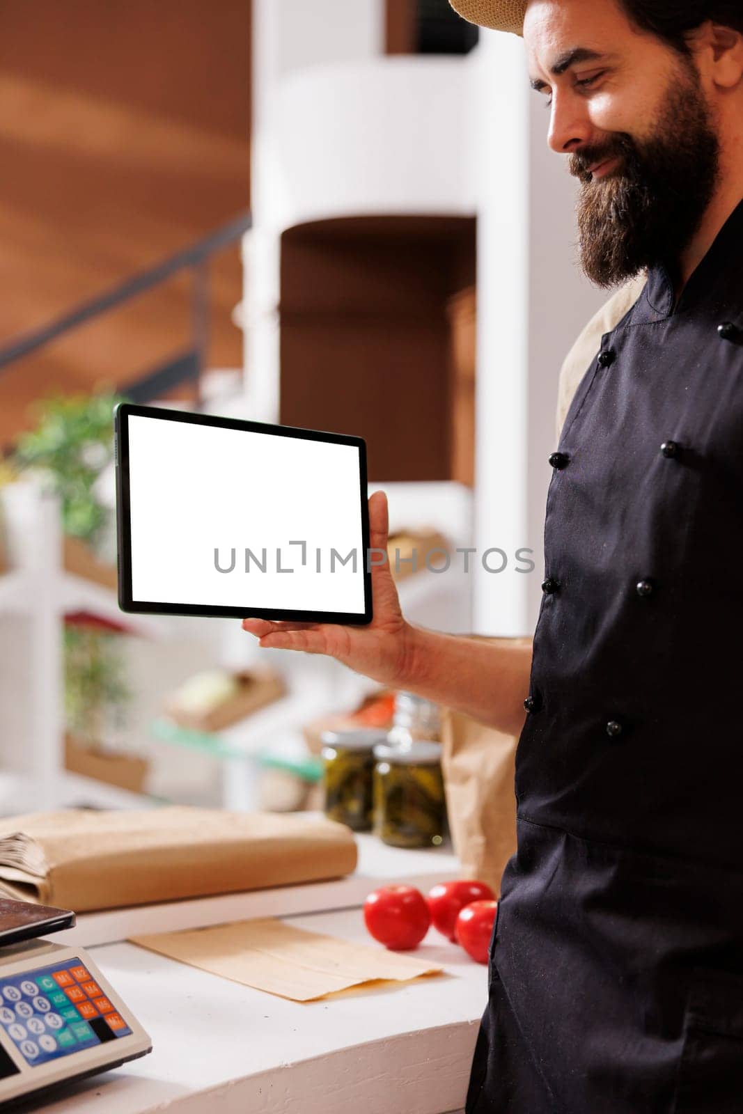 Seller holds tablet with white screen by DCStudio