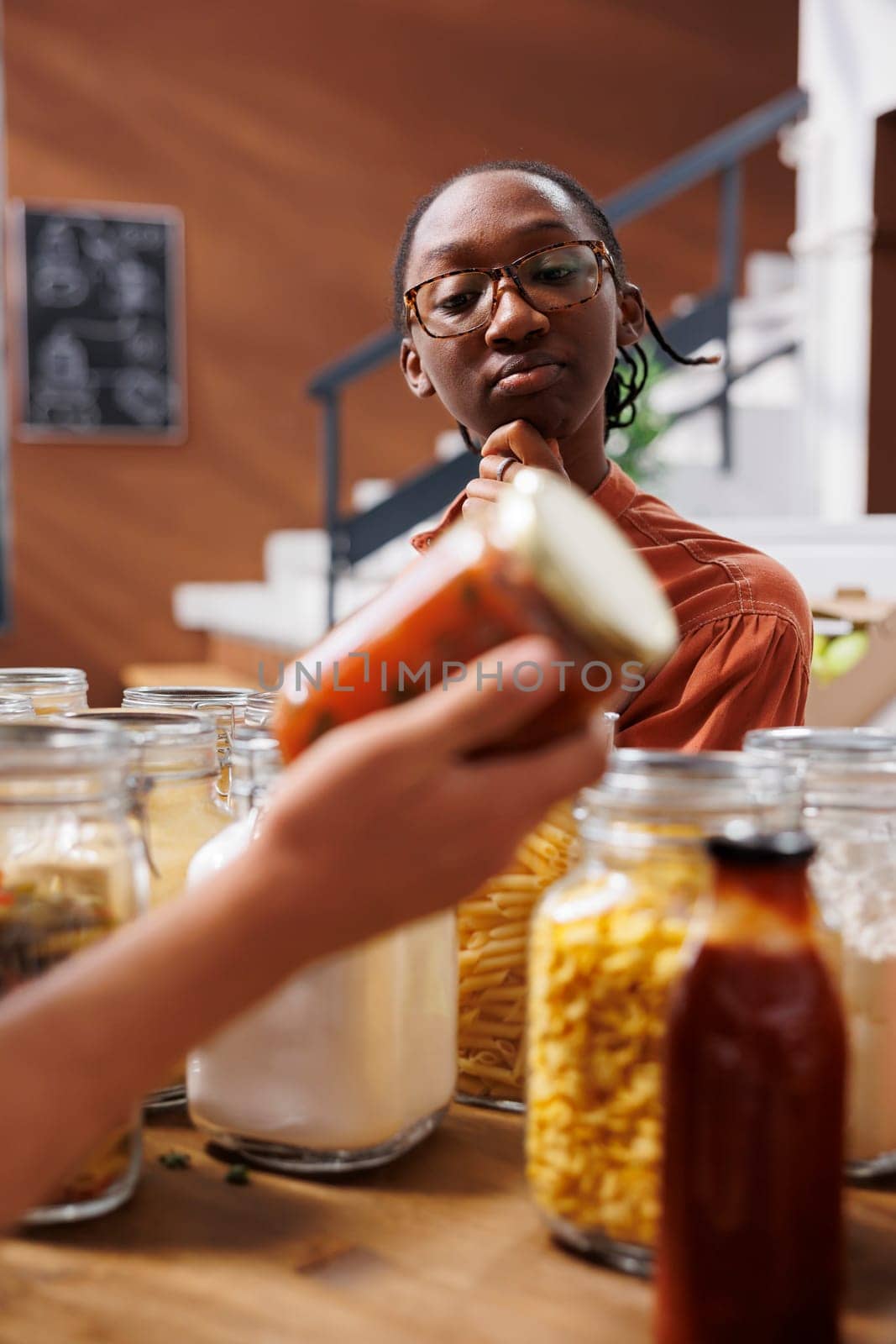 Woman admires jar of red food product by DCStudio