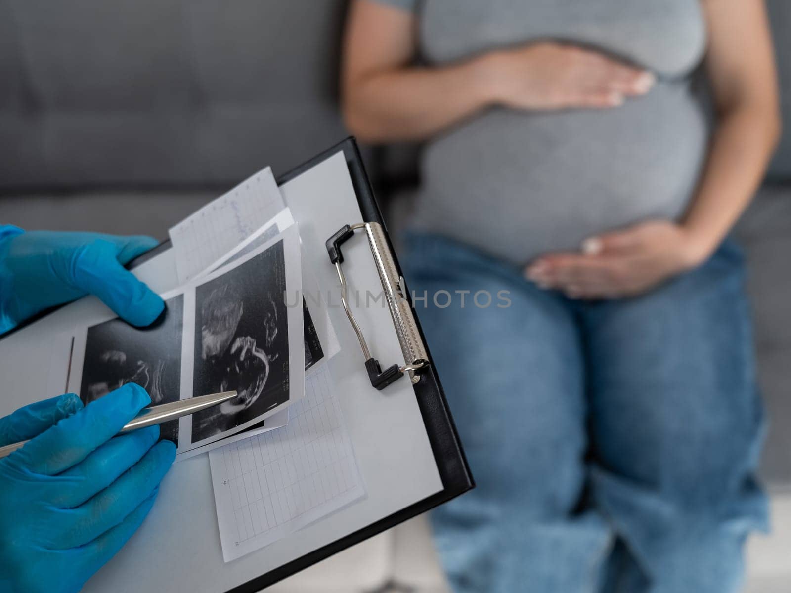 Gynecologist looks at an ultrasound of a pregnant woman