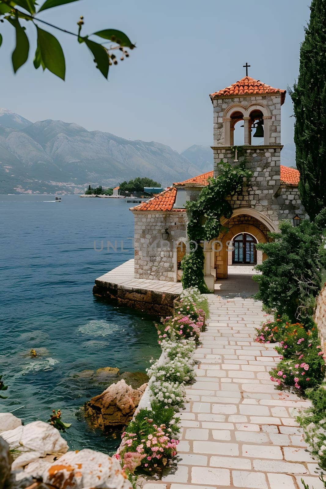A quaint church sits on a small island surrounded by water, with a beautiful natural landscape of sky, plants, and a serene lake. A peaceful place for travel and contemplation