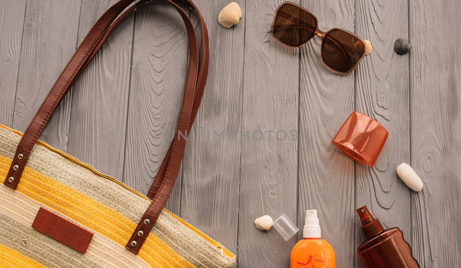 beachwear bag sun protection sunglasses sunscreen spray lotion cream care tan ultra-violet rays. Summer background template mockup free space pattern composition text. Top view above wooden background