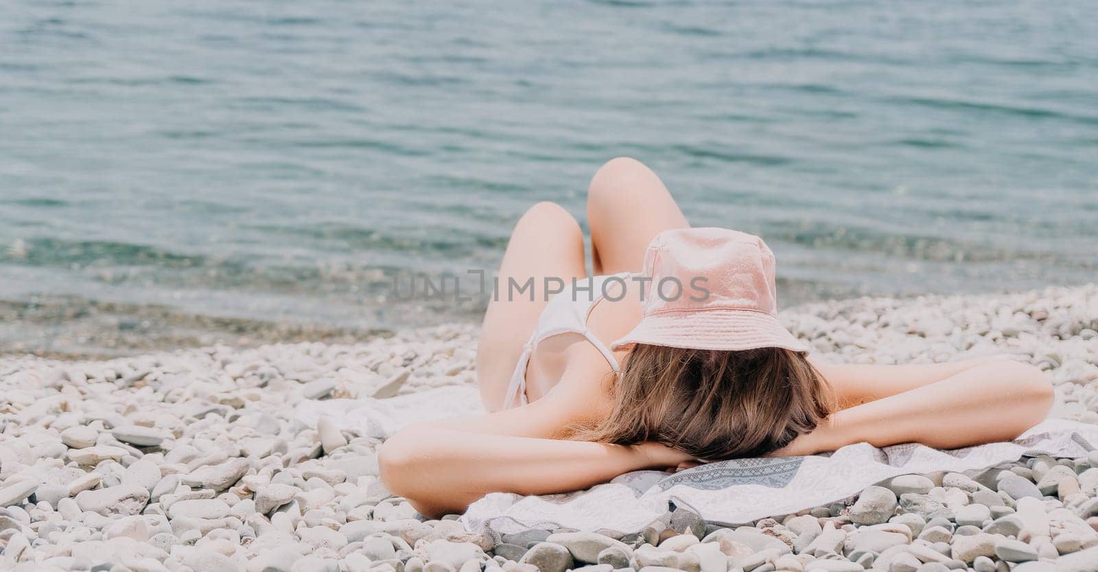 Happy smiling young woman sunbathing or tanning on a seaside beach during summer vacation. Slow motion of happy tourist in red swimsuit enjoying sun tan lying on beach chair lounge at luxury resort.