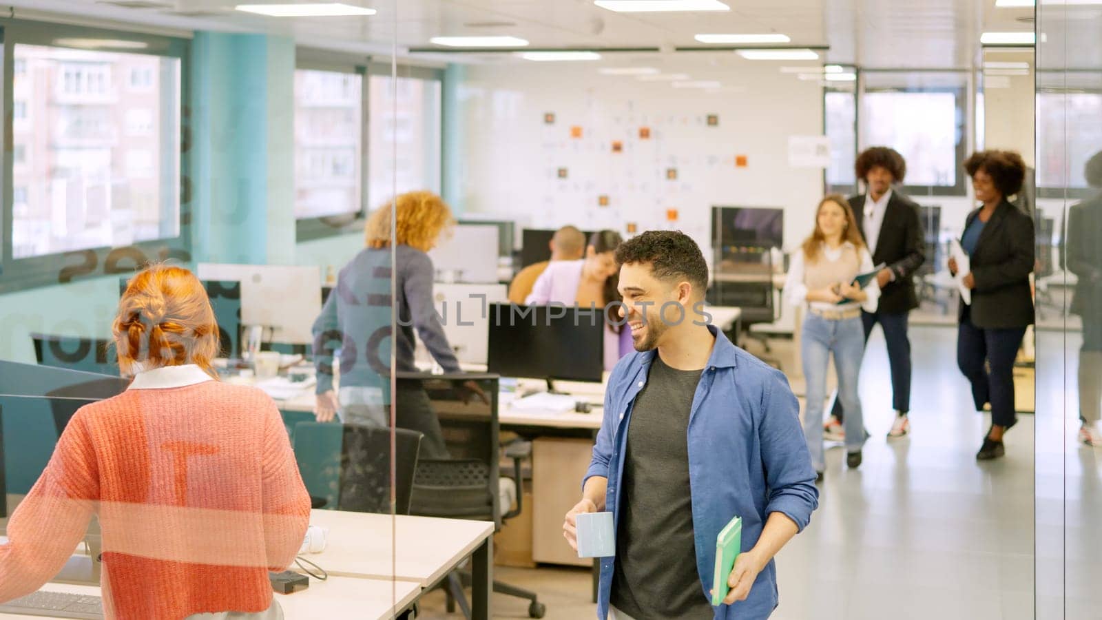 Group of diverse coworkers arriving at the office and sitting on desk one by one