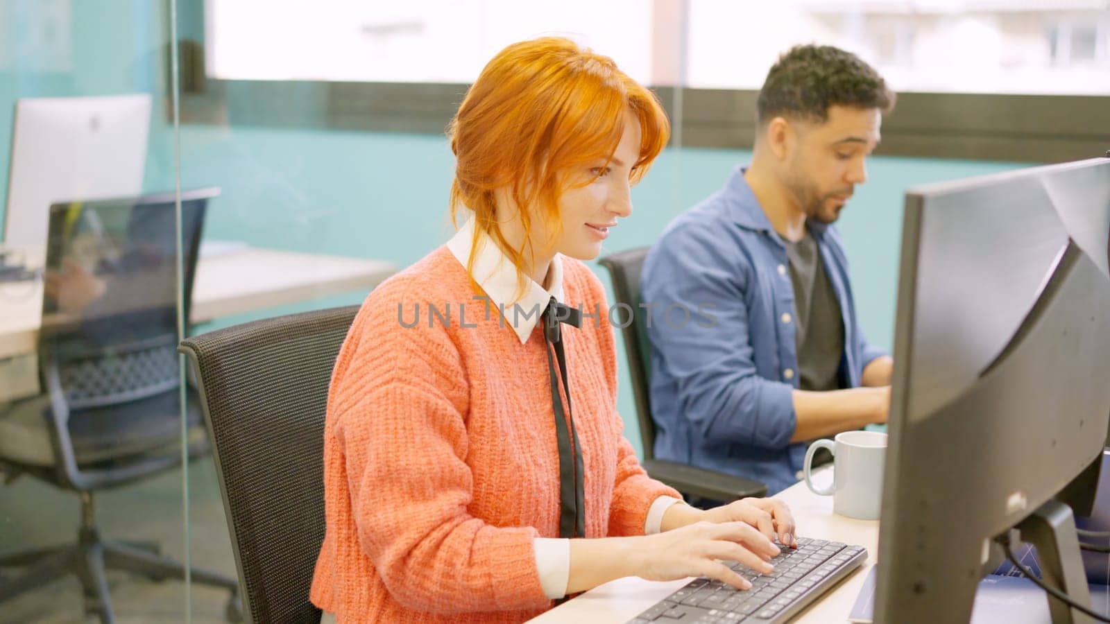 Two male and female colleagues working happily together in a coworking space