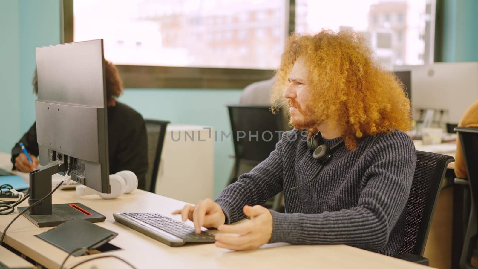 An angry worker experiencing computer problems in a coworking