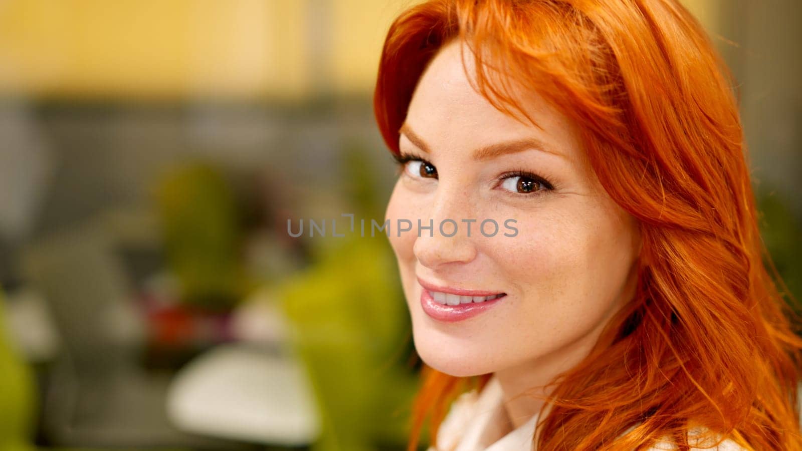 A beauty woman smiling at camera sitting in a coworking