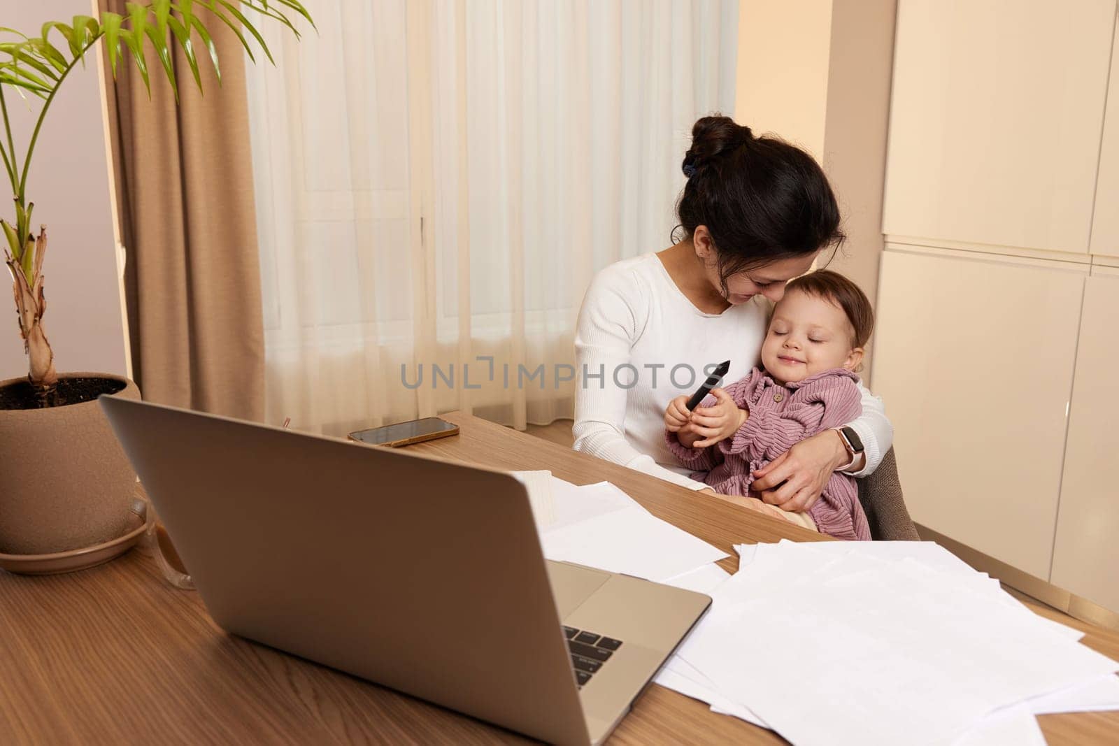 businesswoman working at home with her little child girl by erstudio