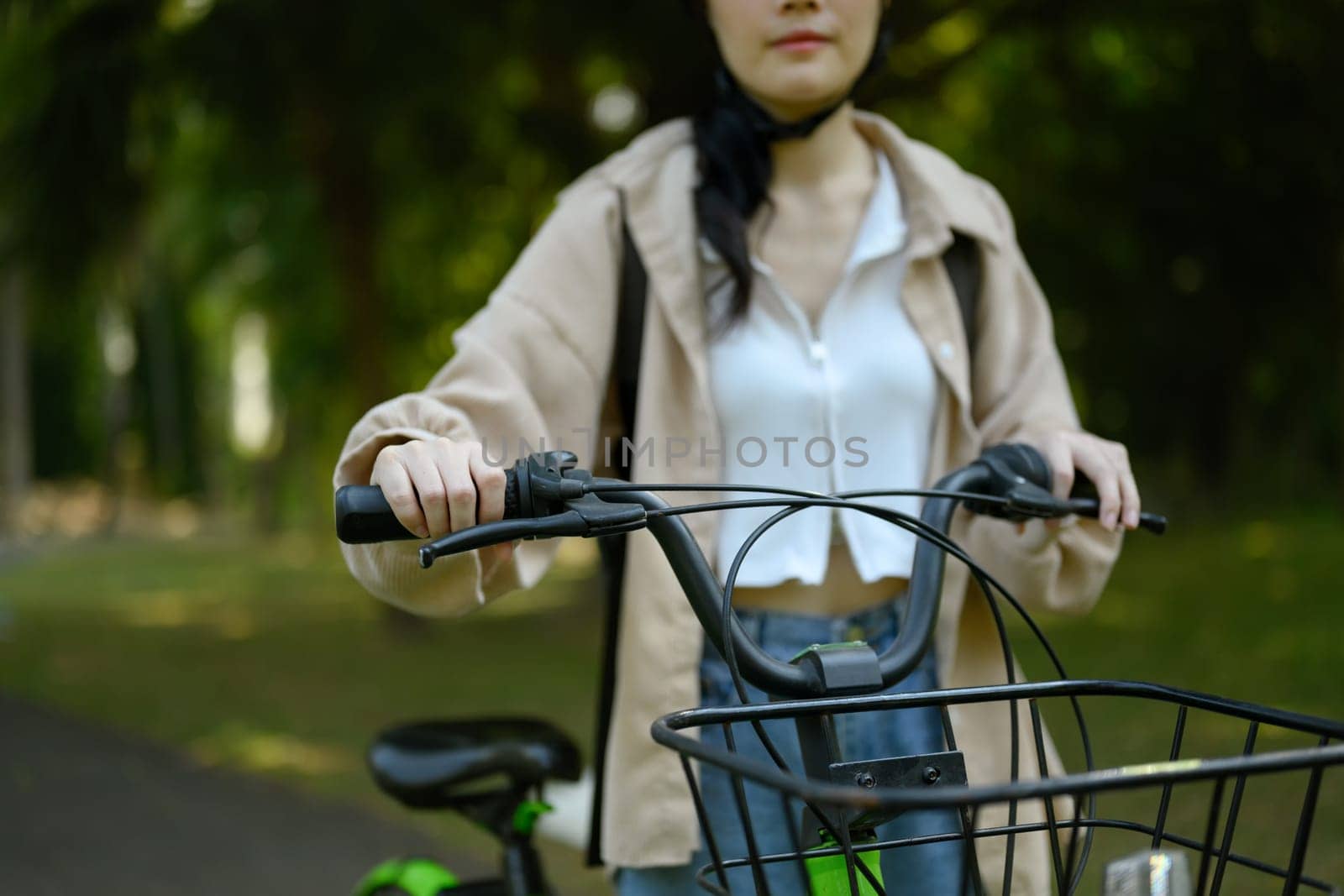 Young woman walking with bike in the public park. Eco friendly transport concept by prathanchorruangsak