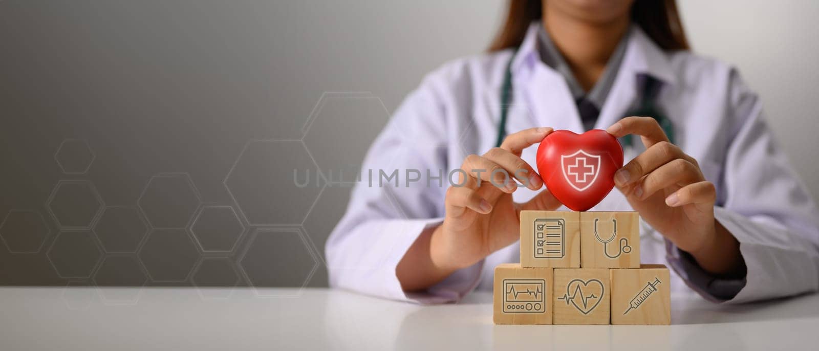 Panoramic photo banner with copy space for text. Doctor holding red heart on wooden cube blocks, health insurance concept by prathanchorruangsak