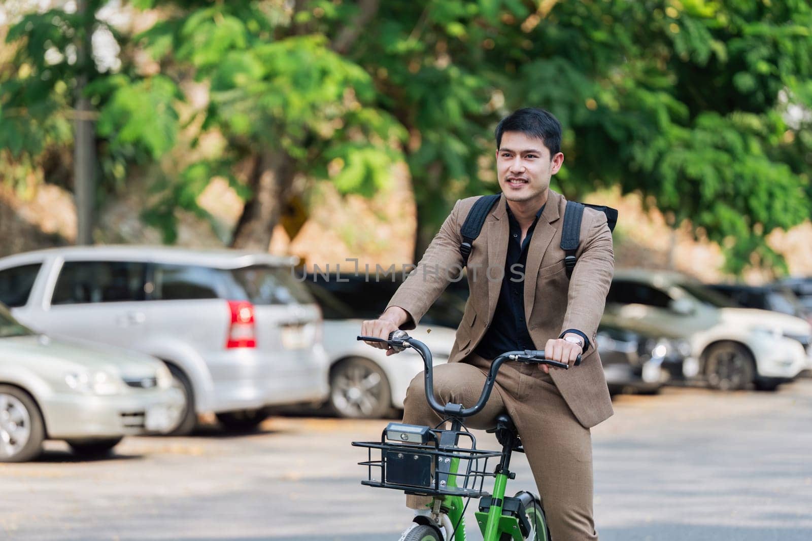 Young businessman ride bicycle to work. Reduce global warming Help save energy. Eco friendly concept by itchaznong