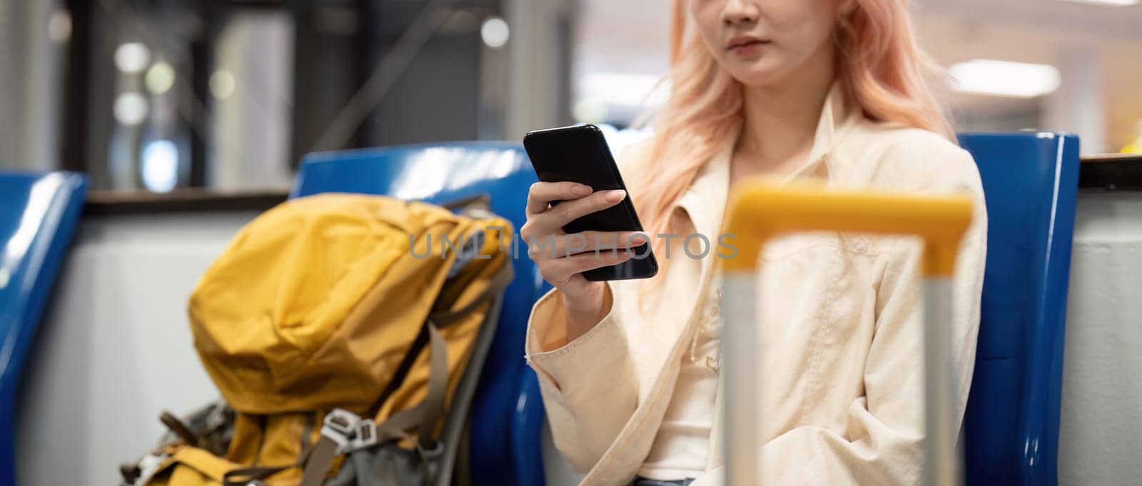 Tourist woman using mobile smartphone with suitcase traveling between waits for flight in Airport Terminal, flight check in, Tourist journey trip concept.
