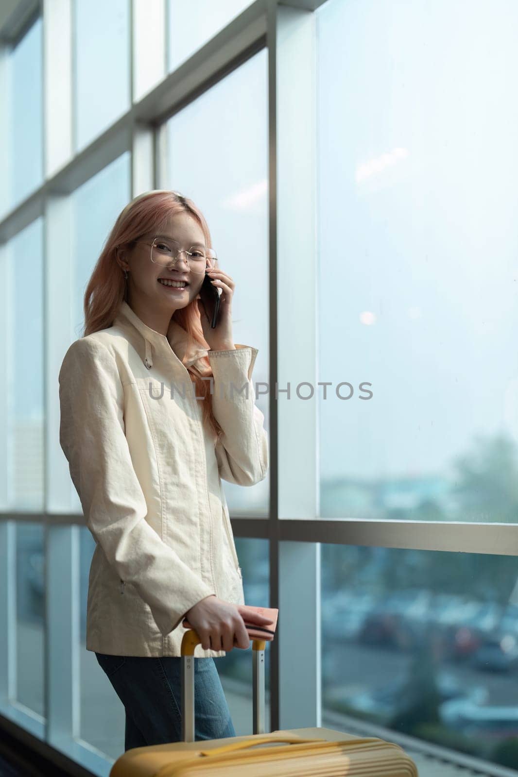 Traveler woman asian in airport and luggage for vacation, smile and talking on the phone check boarding ticket. Female traveler with suitcase, international and departure with passport and trip by nateemee