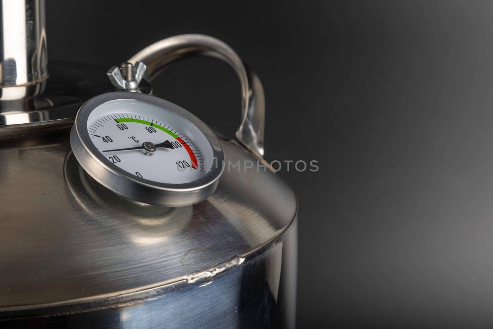 brand new stainless steel alcohol machine or moonshine still on black background.
