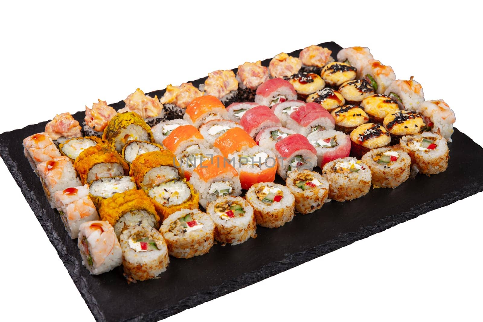 Sushi set served on black stone tray. Various types of sushi rolls served on a slate slab. Isolated on white.
