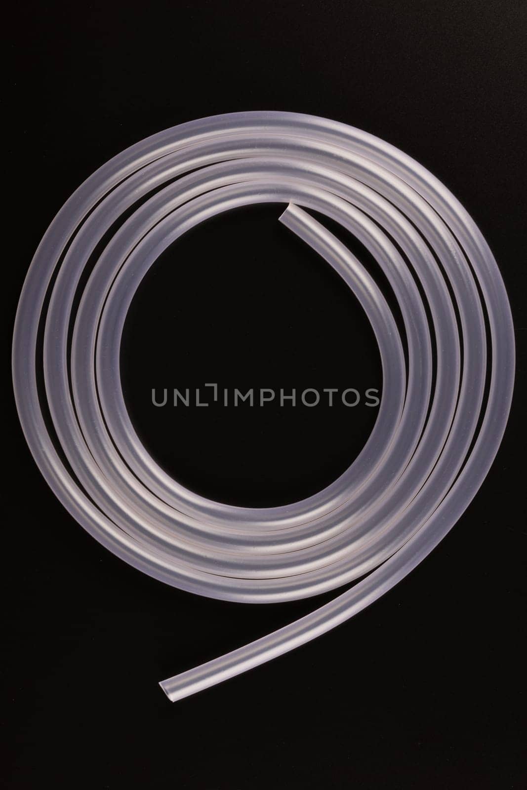 transparent plastic tube coil on black background by z1b