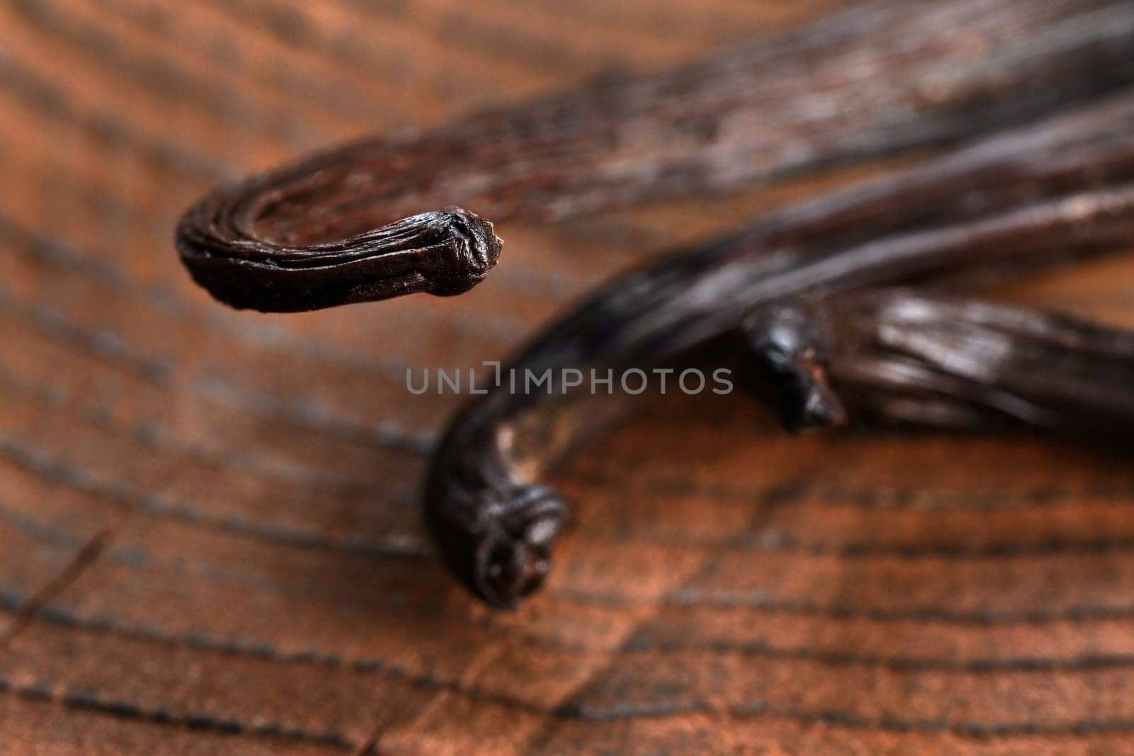 Bourbon Vanilla pods on wooden table, closeup detail on beans tips by Ivanko