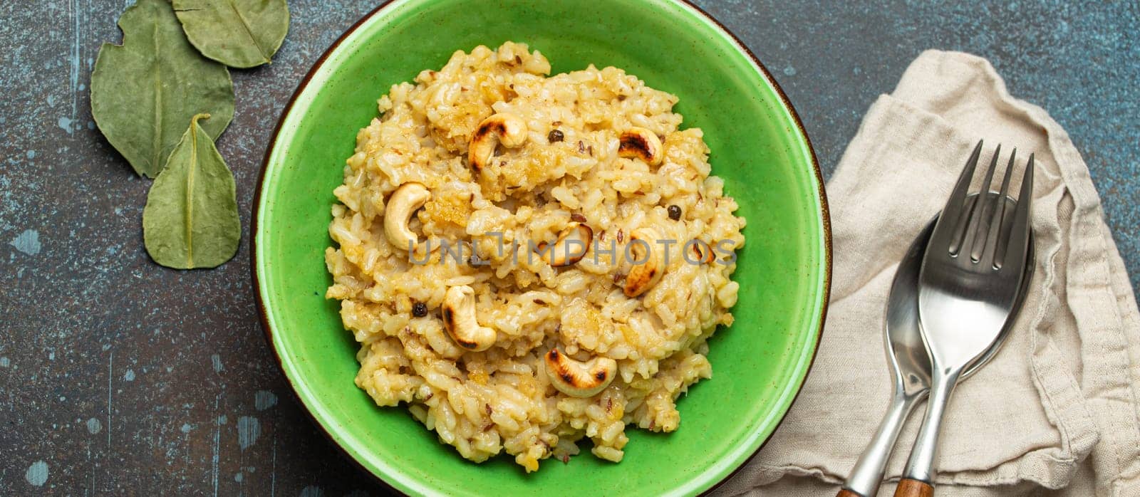 Ven Pongal (Khara Pongal), traditional Indian savoury rice dish made during celebrating Pongal festival, served in bowl top view on concrete rustic background by its_al_dente