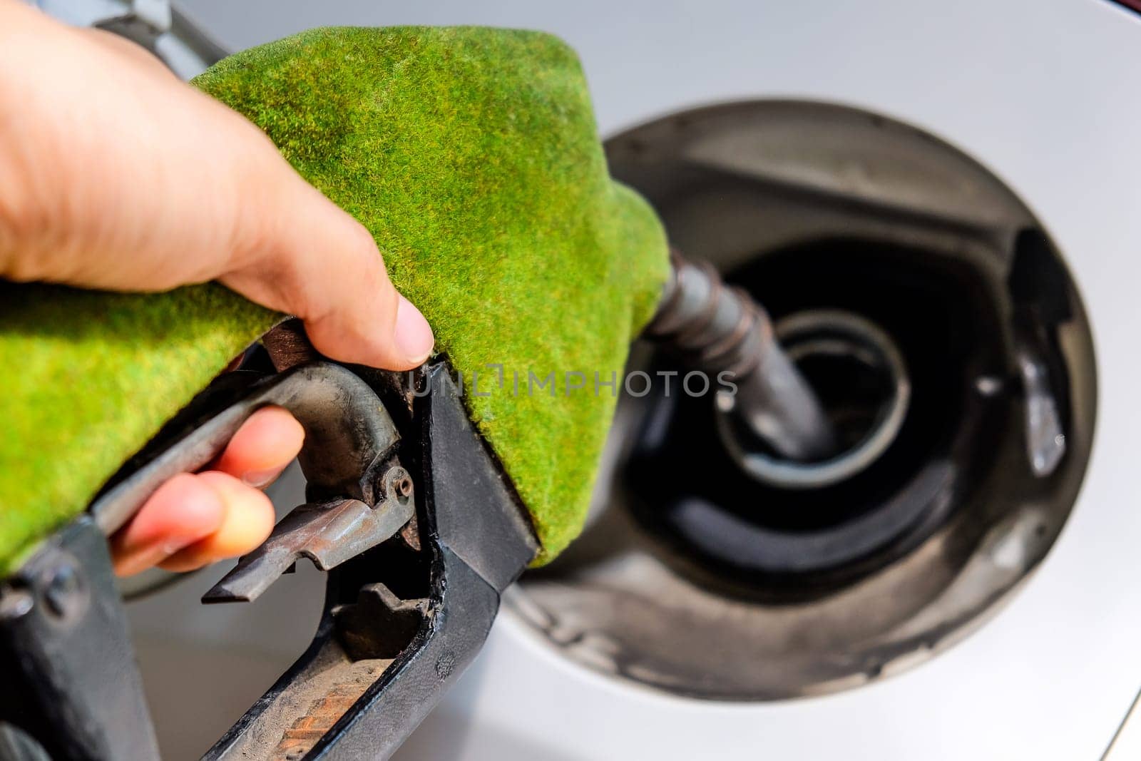 image of hand refilling a car with fuel at a gas station by ponsulak