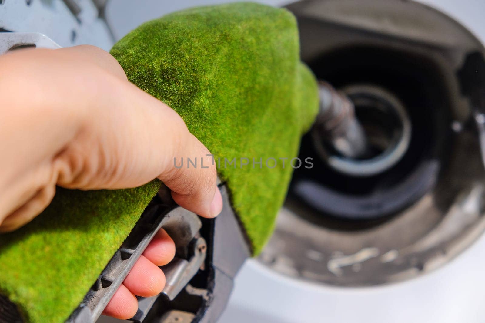 image of hand refilling a car with fuel at a gas station by ponsulak
