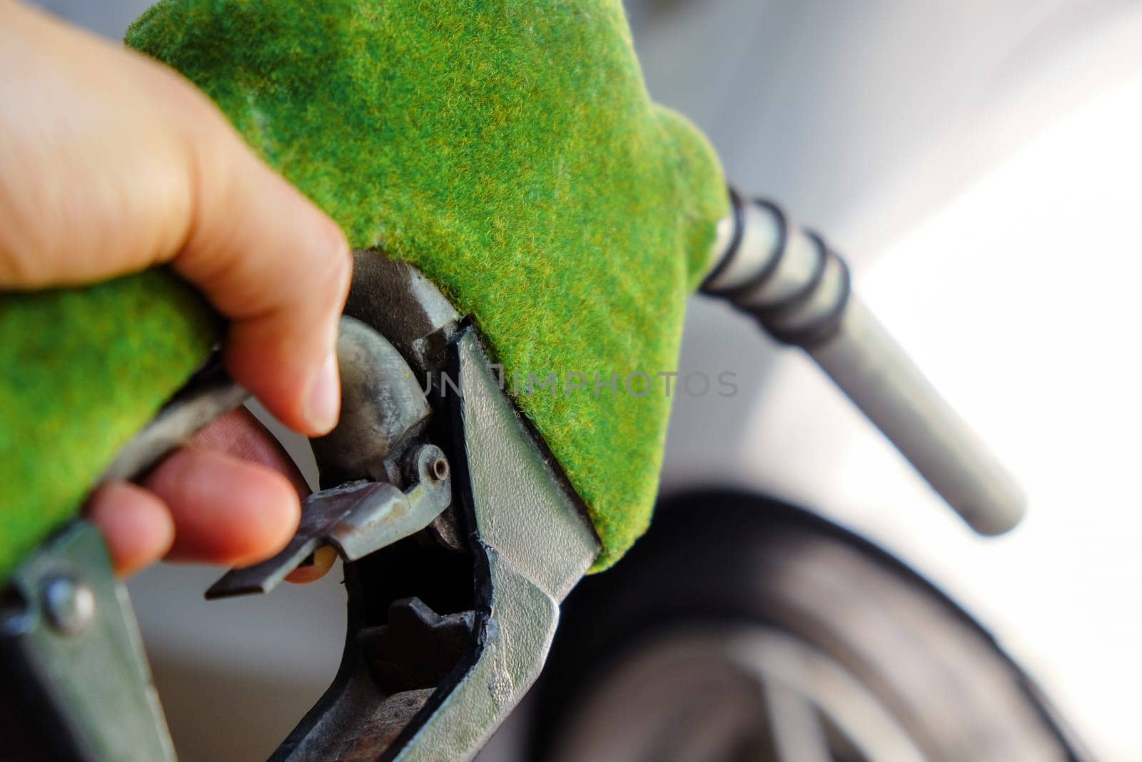 image of hand refilling a car with fuel at a gas station by ponsulak