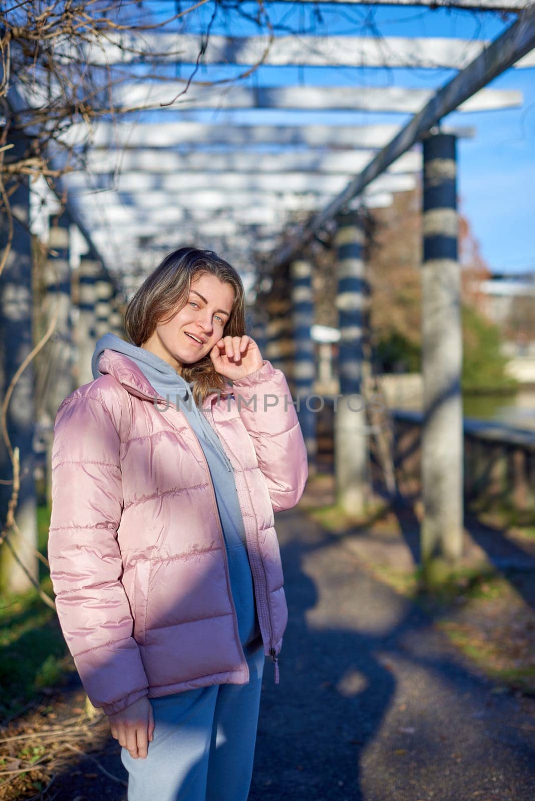 Winter Fun in Bitigheim-Bissingen: Beautiful Girl in Pink Jacket Amidst Half-Timbered Charm. a lovely girl in a pink winter jacket standing in the archway of the historic town of Bitigheim-Bissingen, Baden-Württemberg, Germany. by Andrii_Ko