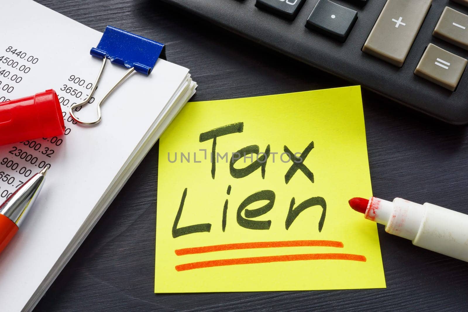 Tax lien concept. The inscription is on a sticker lying near the notepad. by designer491