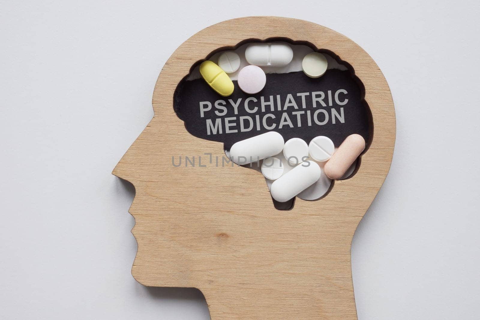 Model of head with pills and an inscription psychiatric medication.