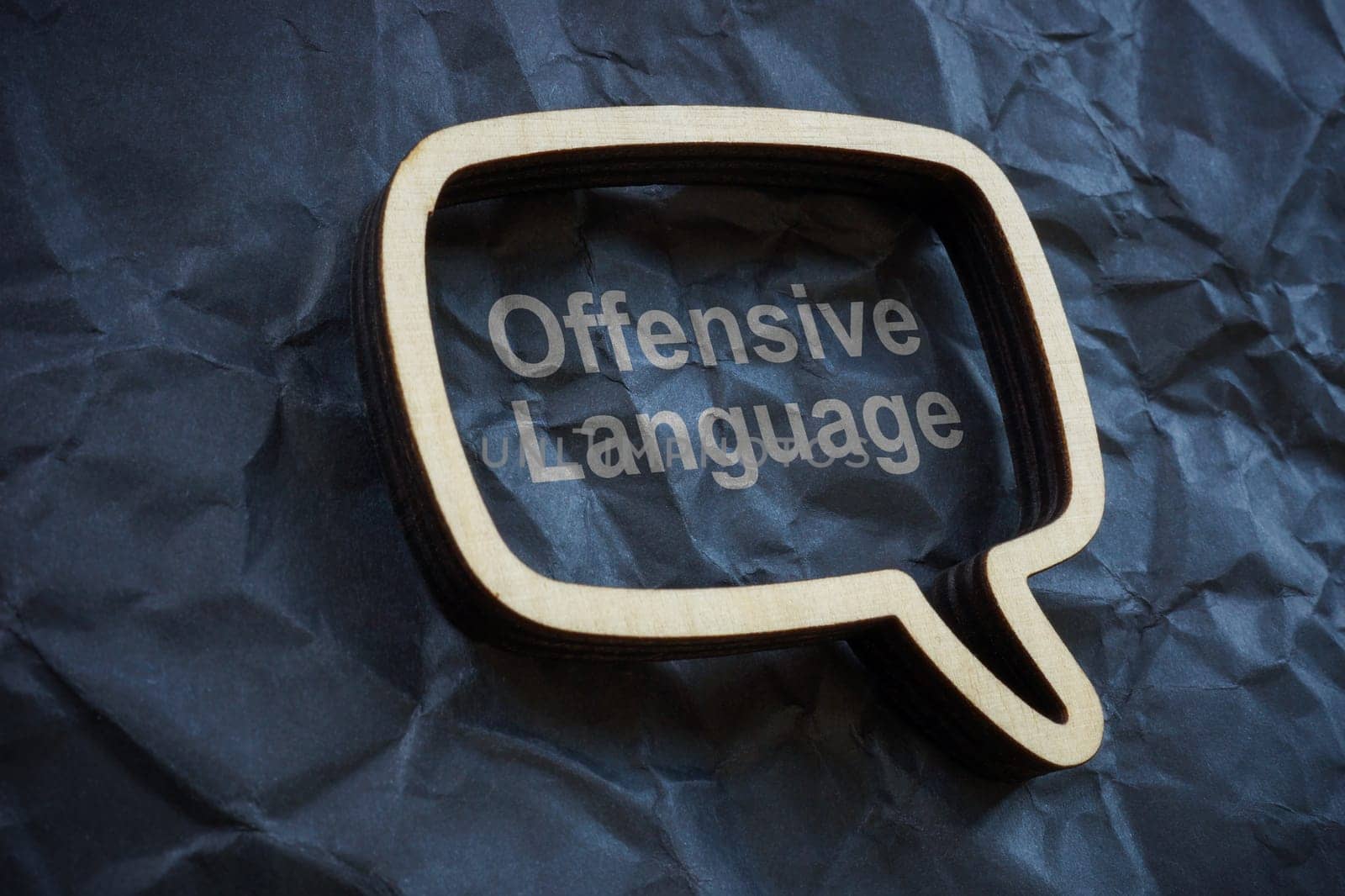 Offensive language concept. Speech bubble on crumpled paper. by designer491