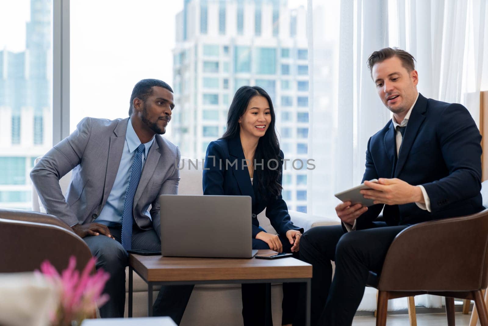 Smart caucasian businessman present marketing idea by using tablet. Group of business team listening while deciding to invest in start up project at modern lounge. Ornamented.