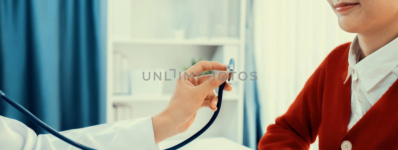 Patient attend doctor's appointment at clinic or hospital office. Doctor examining and diagnosis symptoms while checking the patient's pulse with stethoscope. Panorama Rigid