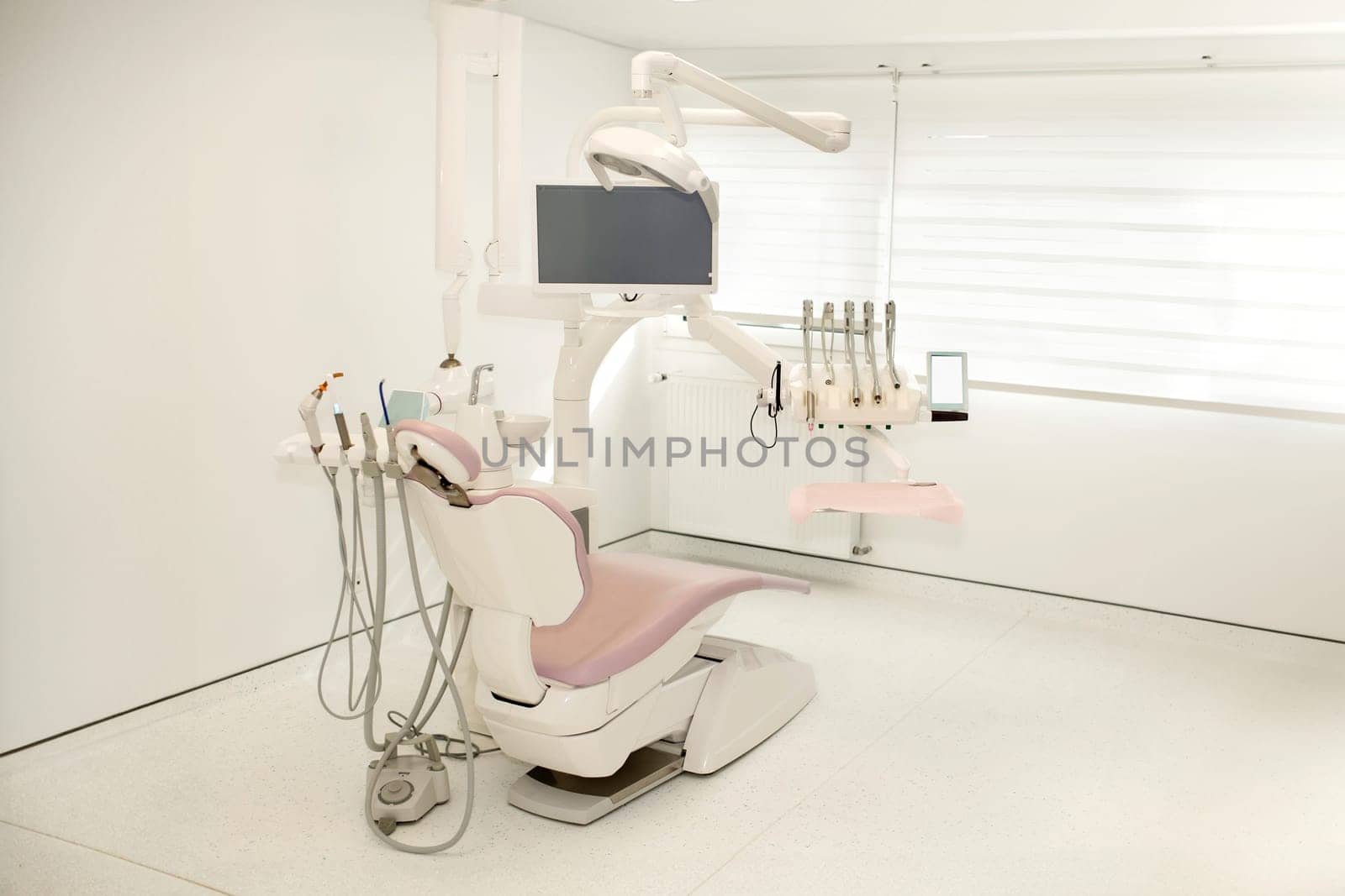 Pink dental chair in a modern dental office by Godi