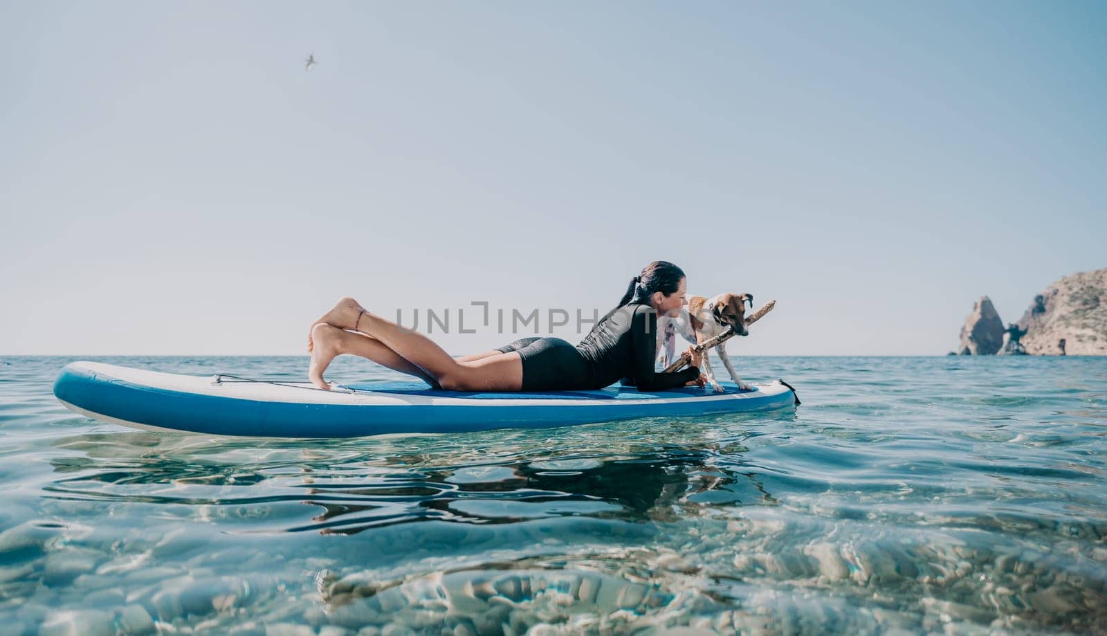 Sea woman sup. A happy positive woman in hat with family relaxing in sea, aerial back view of family on SUP board floating on calm water. Active lifestyle at sea. Summer vacation. Slow motion