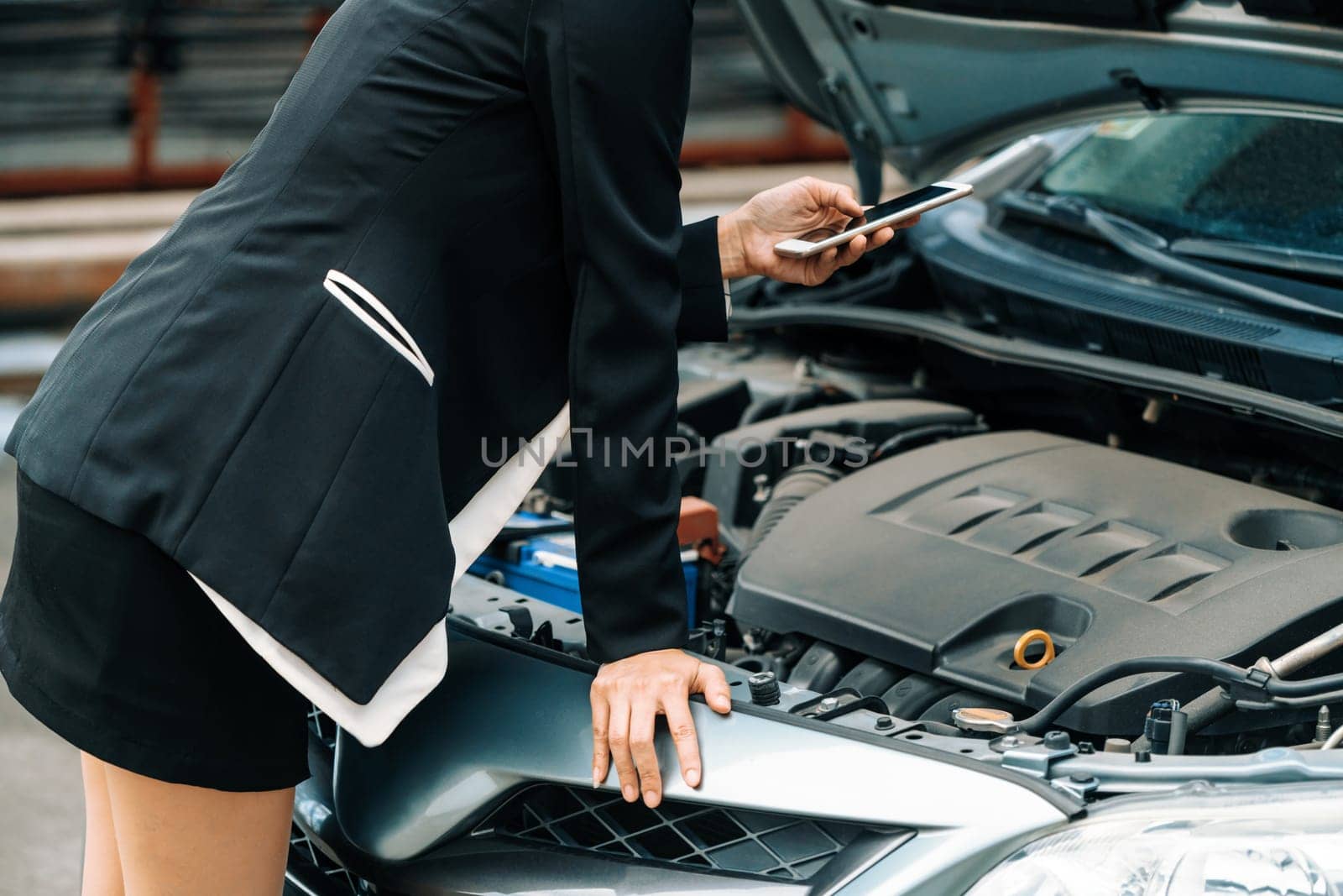 Young businesswoman whose car breakdown uses mobile phone to call for roadside assistance service. Travel and transportation vehicle problem. uds