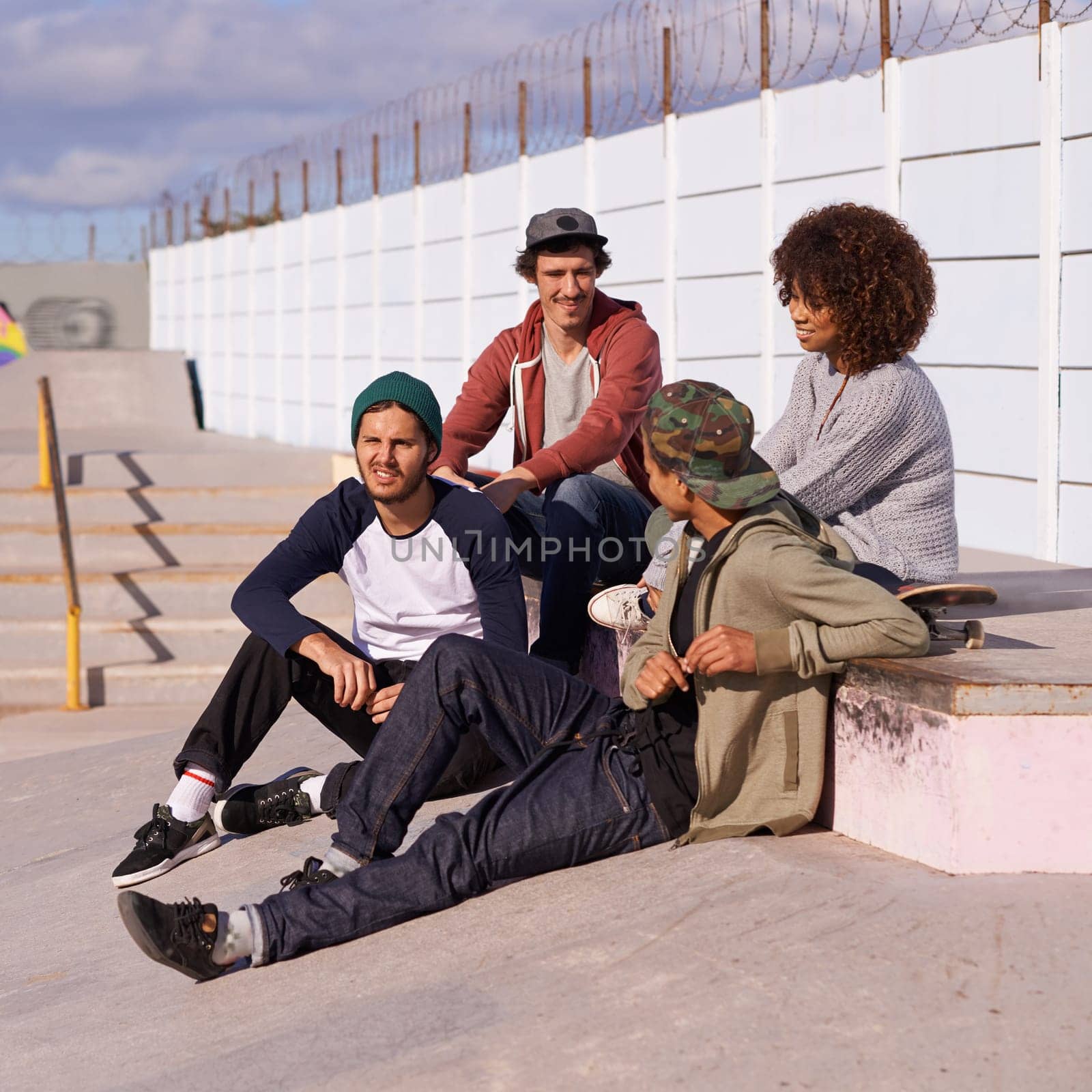 Skate park, diversity and group with conversation, sunshine and relaxing after training for competition. Multiracial, friends and team on a break, summer and bonding together with skaters in a park.