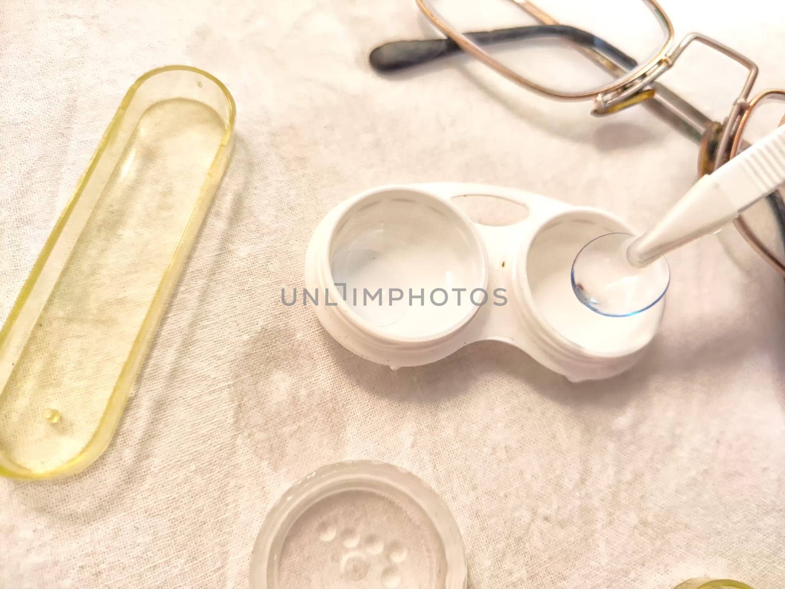 Set for contact lenses with a container, forceps, glasses. The concept of correcting myopia. Contact lens care, cleaning, health. Background, copy space