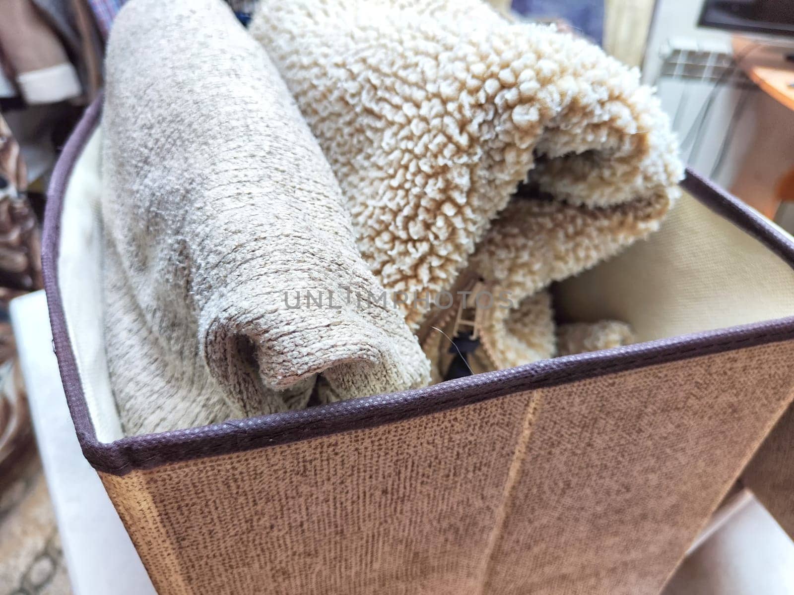 Organized Clothing Storage Using Konmari Folding Method. Neatly folded clothes arranged vertically in a storage box