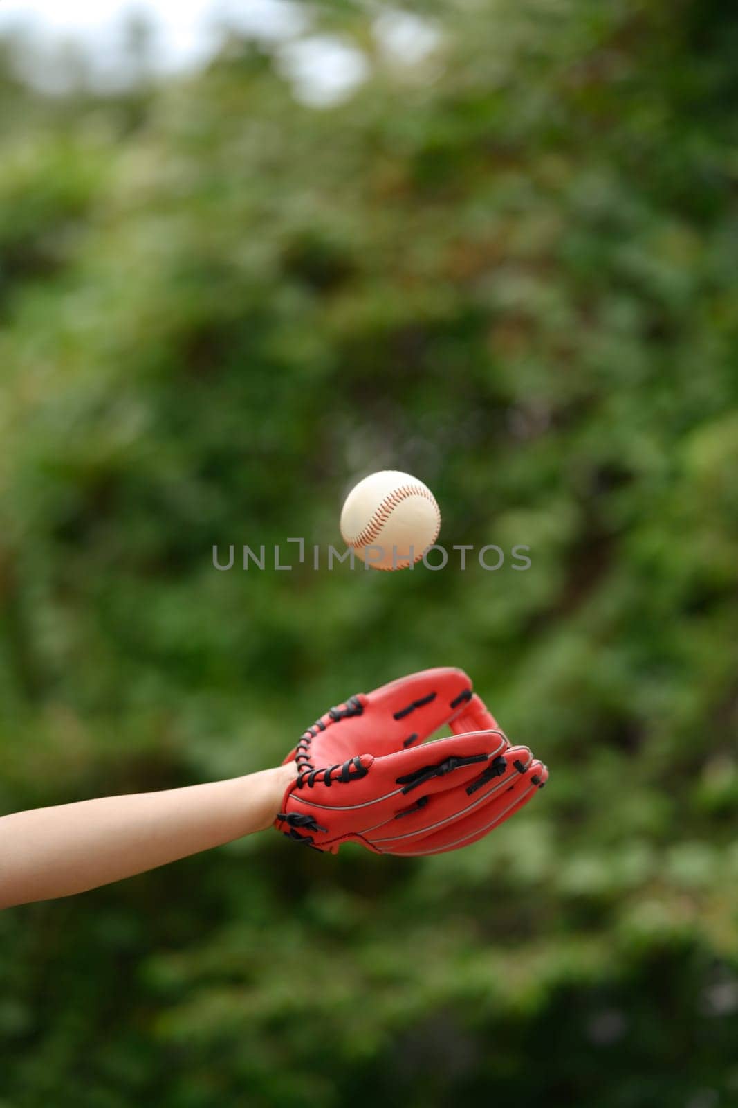 Baseball player in leather baseball glove catching a ball. Sport, activity and people concept.