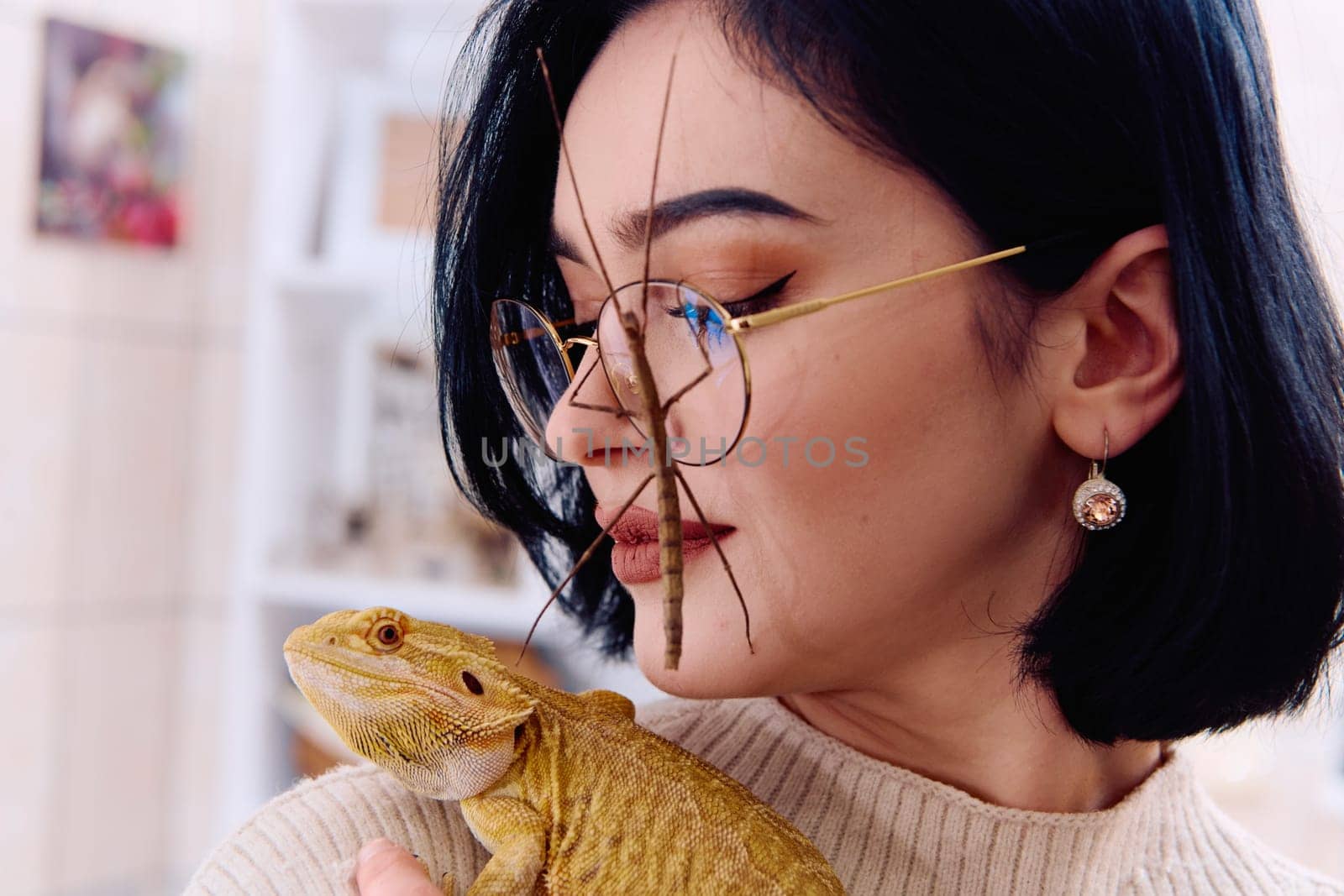 A young woman poses with her two pets, a bearded dragon and a stick insect, in this heartwarming photo.