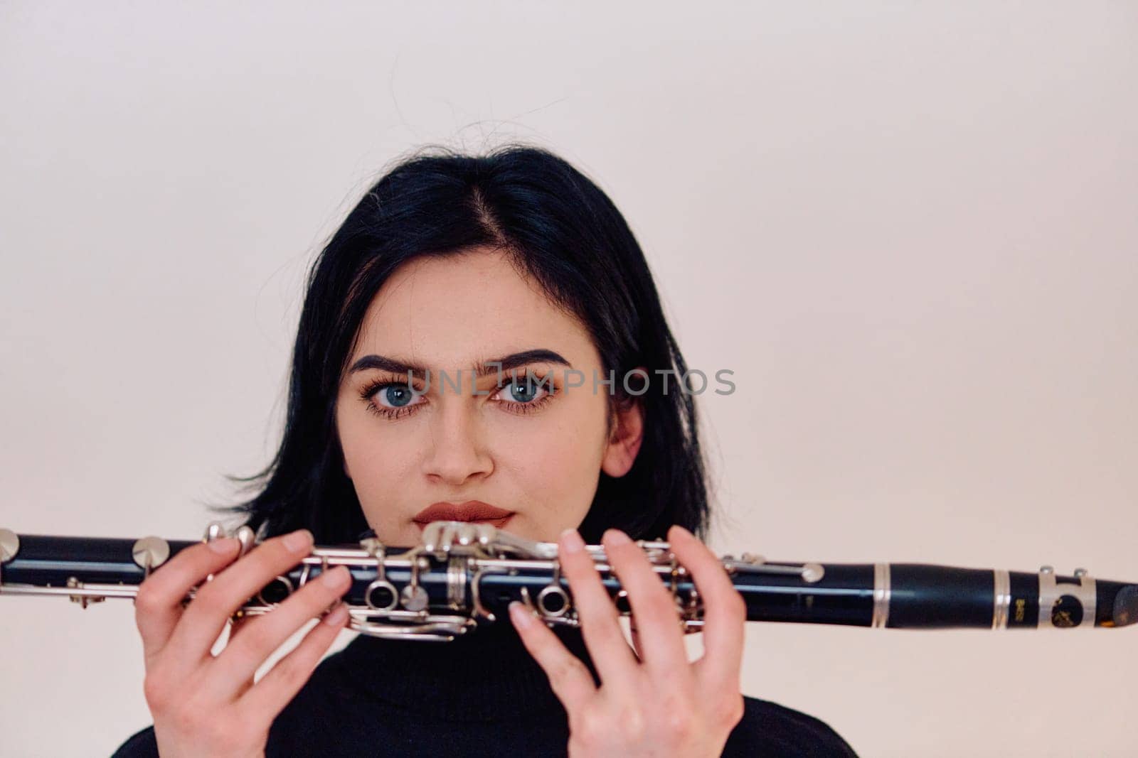 Graceful Brunette Musician Posing with Clarinet on White Background by dotshock