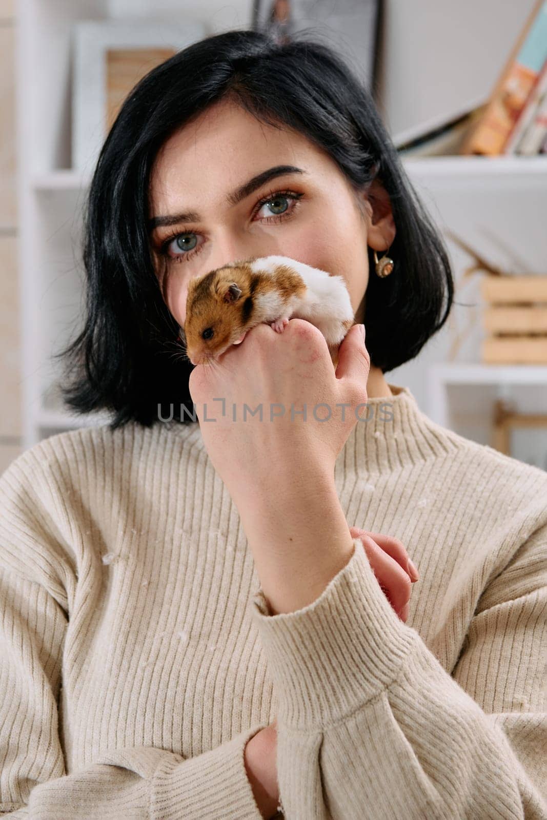 A black-haired woman enjoys a cozy day at home with her pet mouse, the two of them sharing a playful moment in the warm light of the living room.