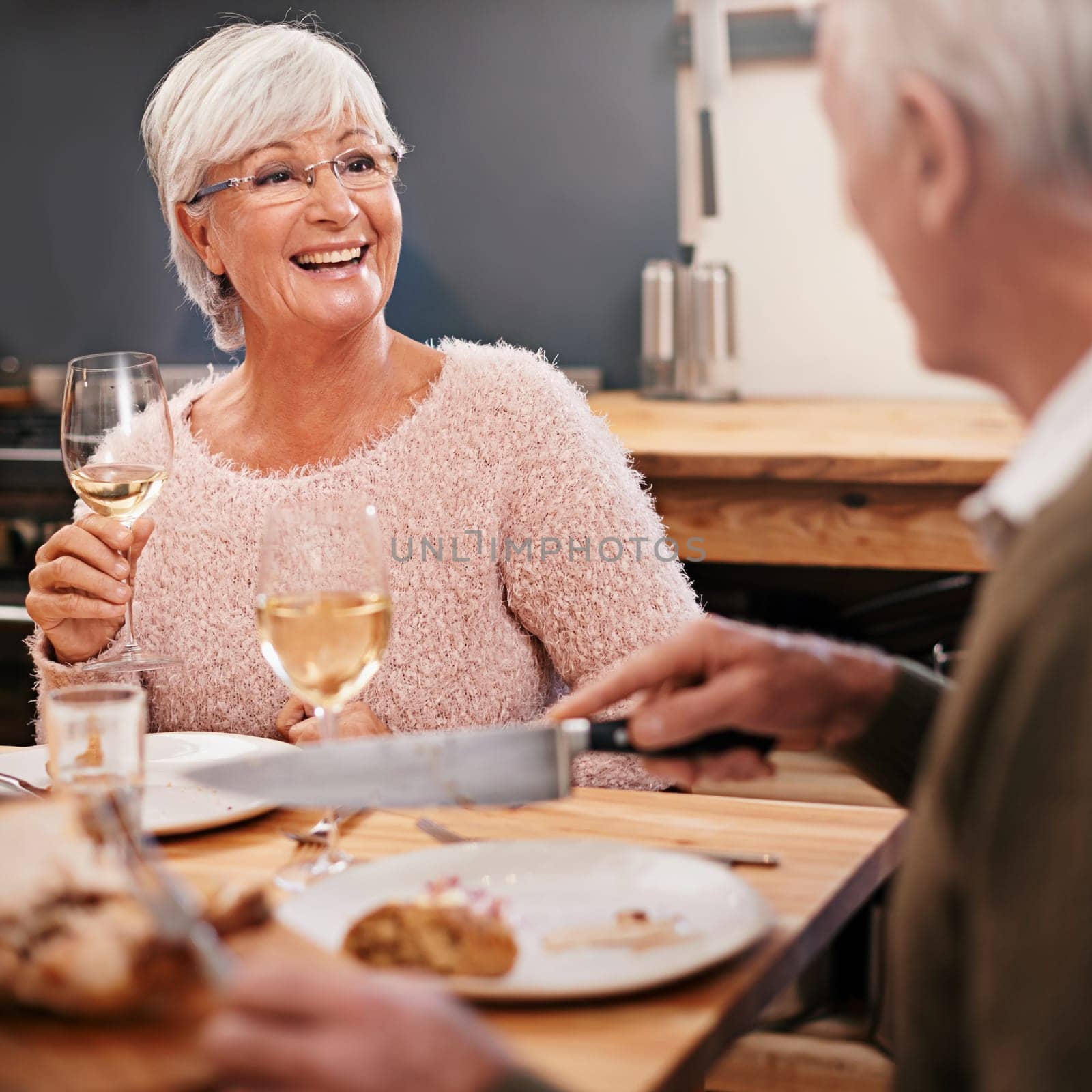 Senior couple, food and alcohol for love at table, conversation and healthy meal in home for anniversary. People, bonding and eating together on weekend, relax and speaking on romantic dinner date.