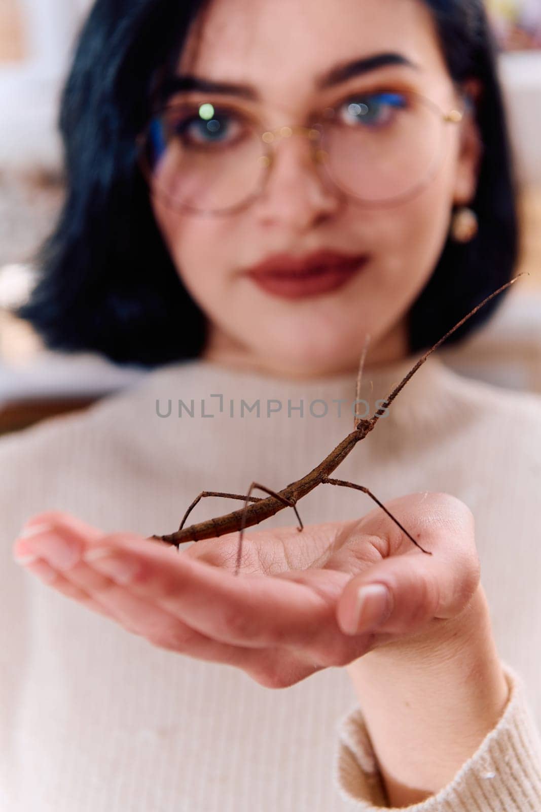 A serene moment as a young woman poses with her beloved stick insect, showcasing the unique bond between human and arachnid.