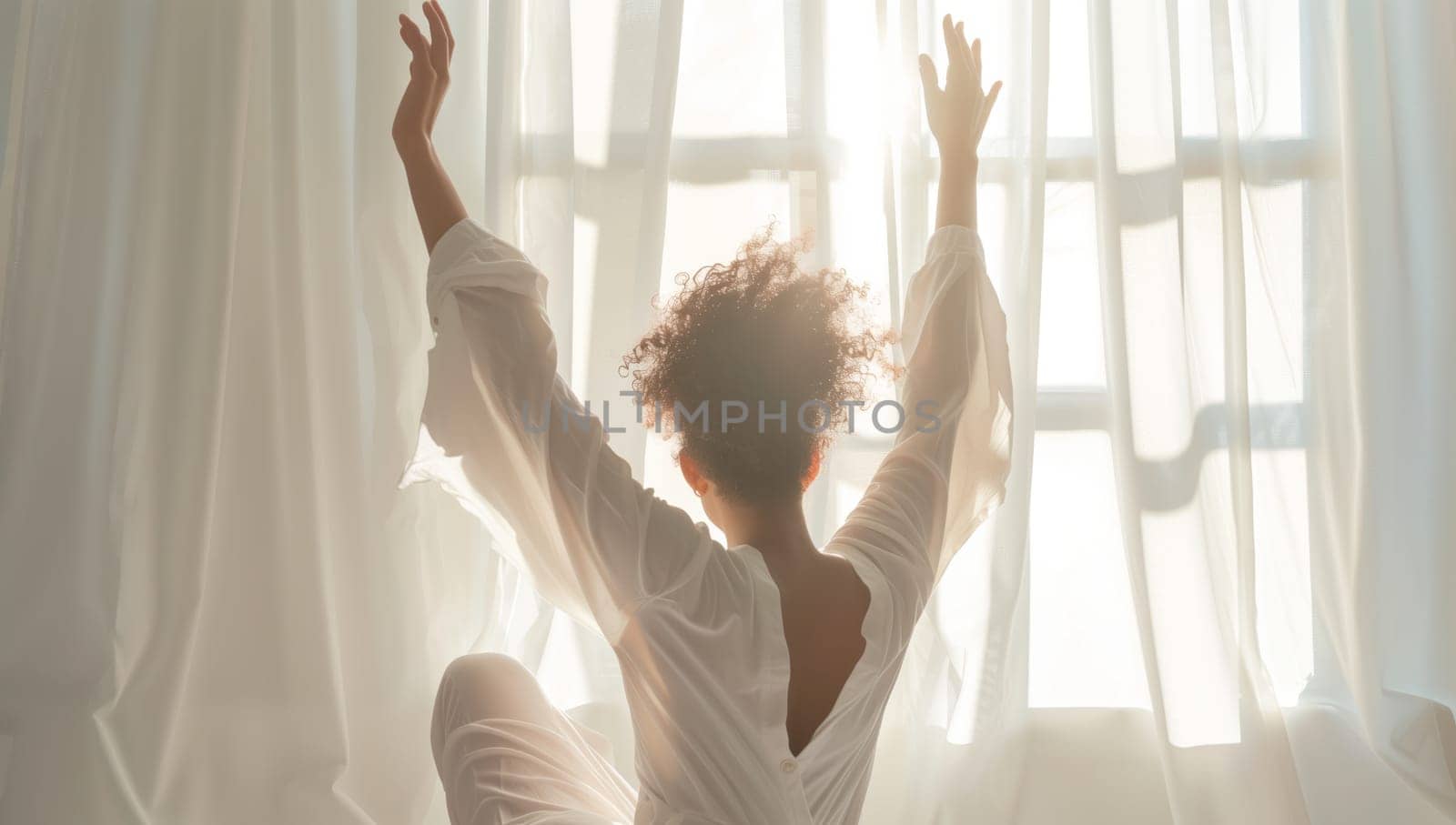 A woman in a flowing dress is seated in front of a window, with her arms outstretched in a happy gesture, showcasing the elegance of performing arts