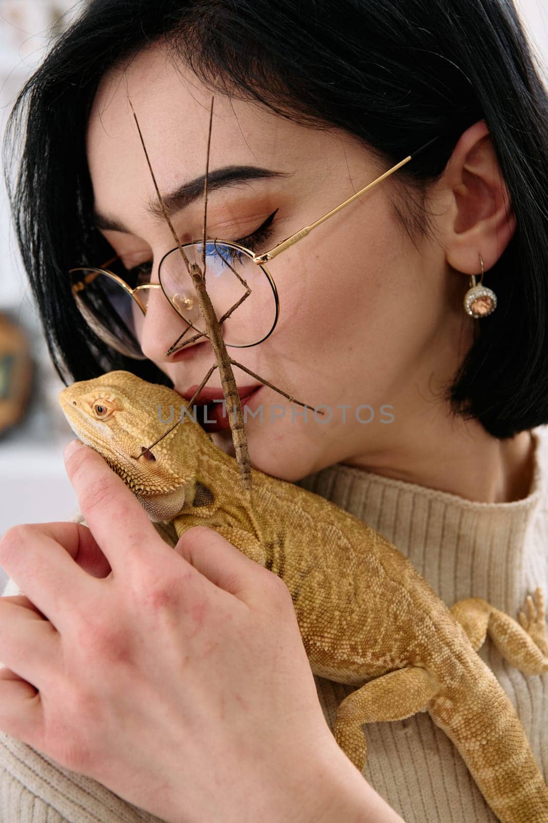 A young woman poses with her two pets, a bearded dragon and a stick insect, in this heartwarming photo.