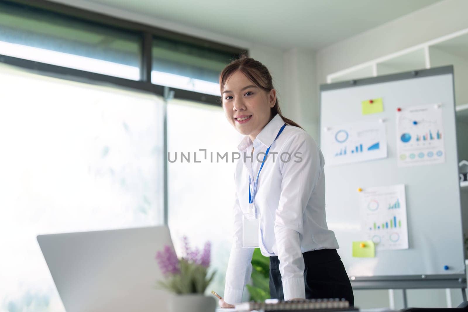 Young successful employee or business woman at desk at office. Achievement career concept by nateemee