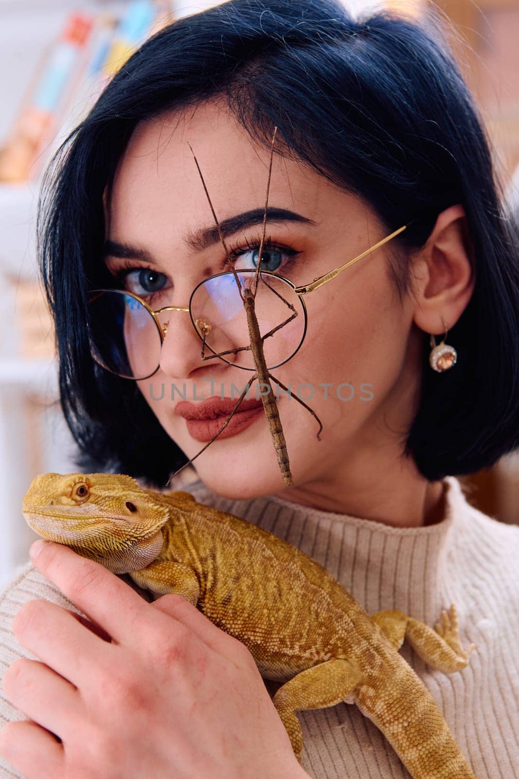 A young woman poses with her two pets, a bearded dragon and a stick insect, in this heartwarming photo.